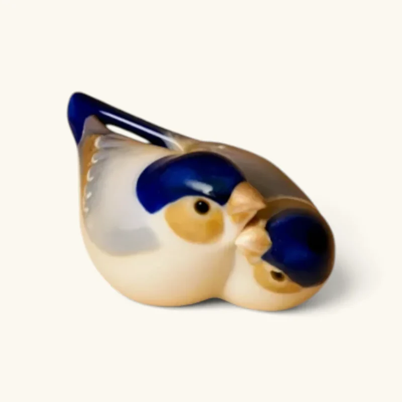 Royal Copenhagen figur nr. 1505 – Blåmejse i naturtro porcelænsdesign, ca. 10 x 4 cm. Designet af Peter Herold i 1913. Et charmerende samlerobjekt med håndmalet underglasur og klassisk dansk dyrefigurkunst