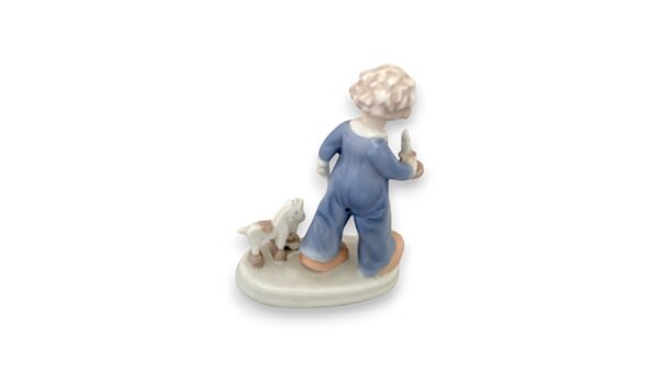 Lille dreng i nattøj med stearinlys og træklegetøj